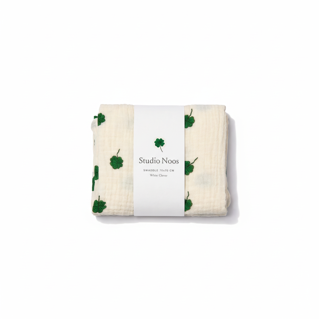 Soft Clover Swaddle by Studio Noos featuring a green and white geometric pattern, perfect for cozy baby comfort.