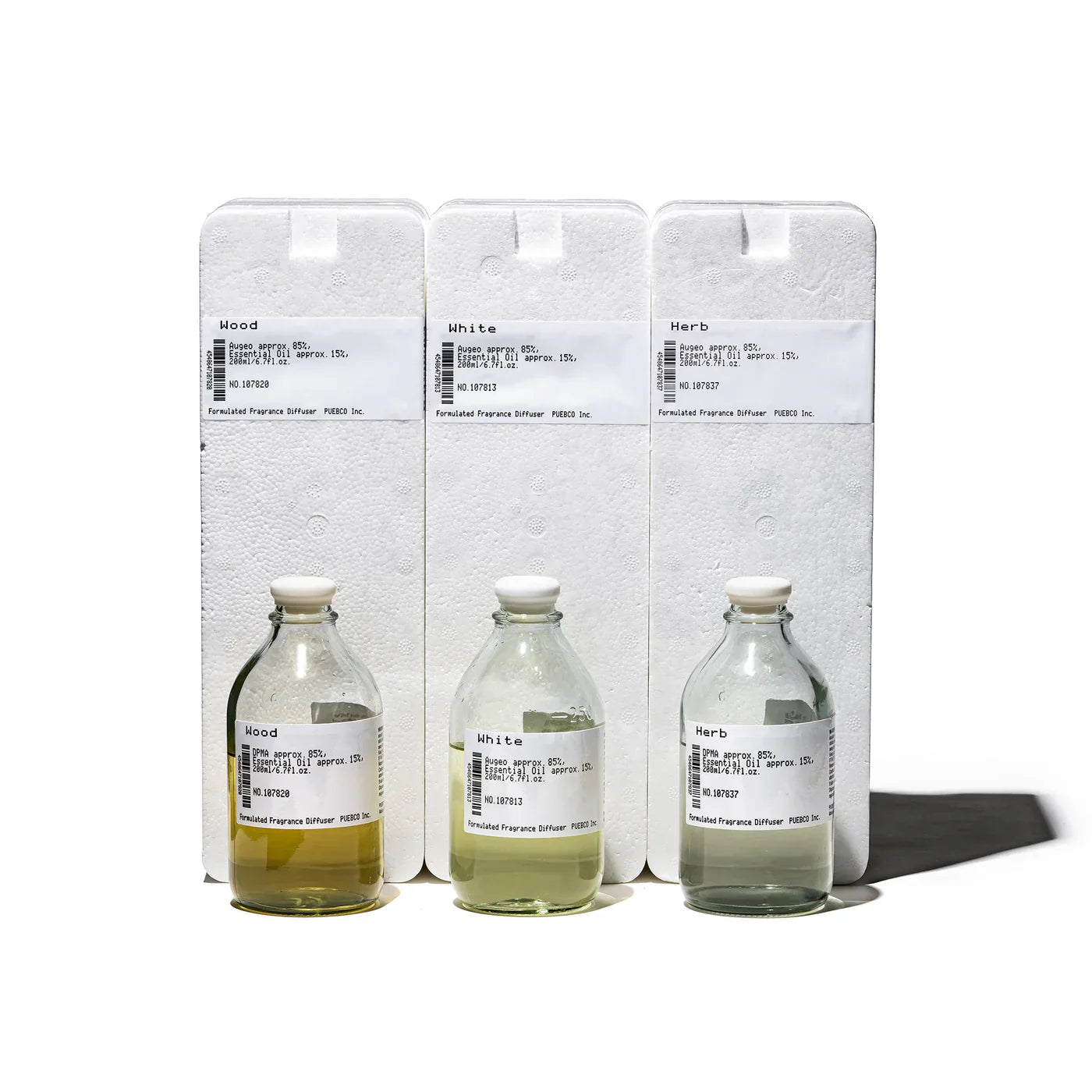 Puebco formulated fragrance diffuser with sleek glass bottle and minimalist design, emitting a subtle aromatic mist.