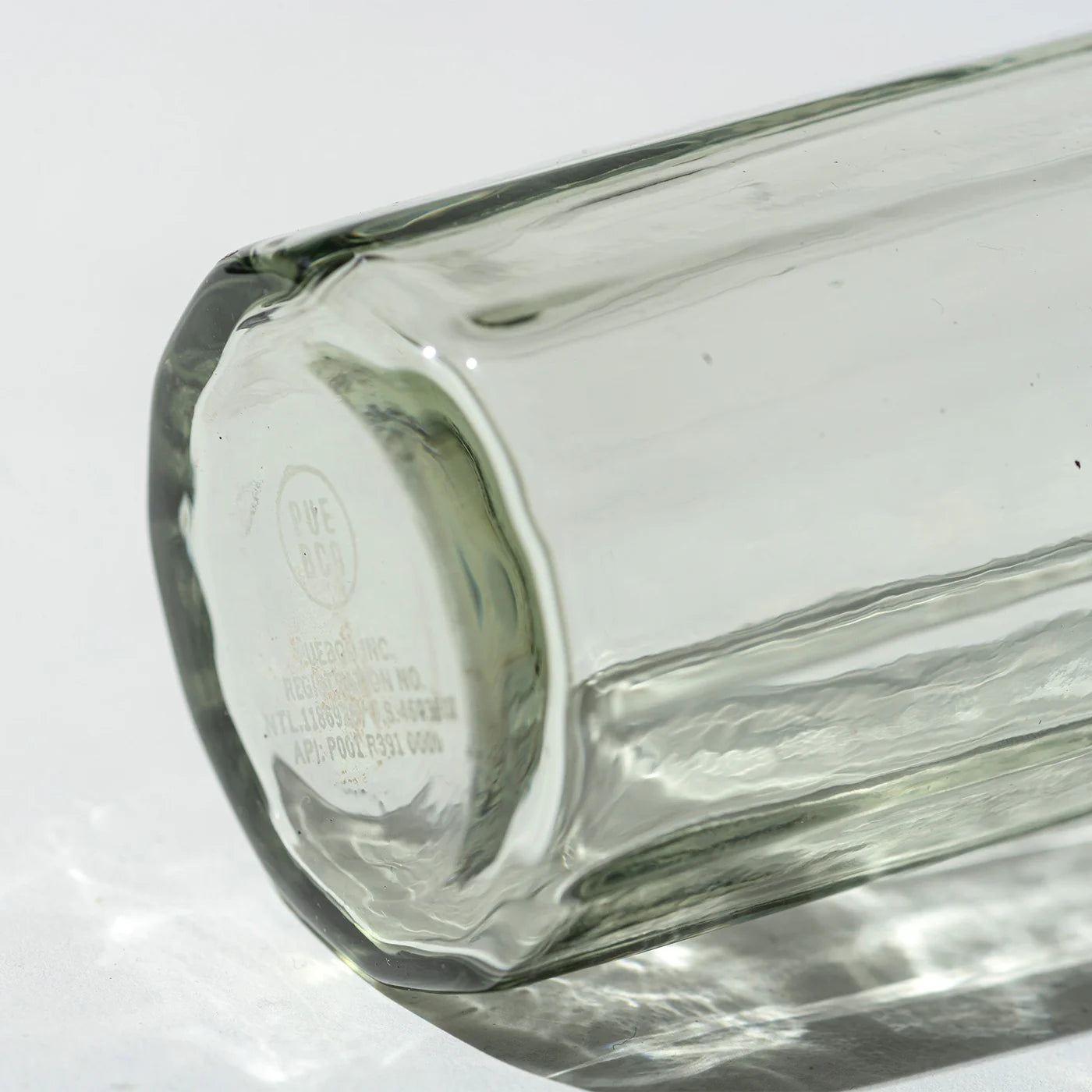Recycled glass vase by Puebco with a smooth, transparent surface and rounded shape, ideal for decorative or floral arrangements.