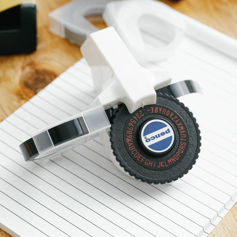 Penco Tape Writer labelmaker with black and white tape loaded, showing the compact handheld design on a white background.
