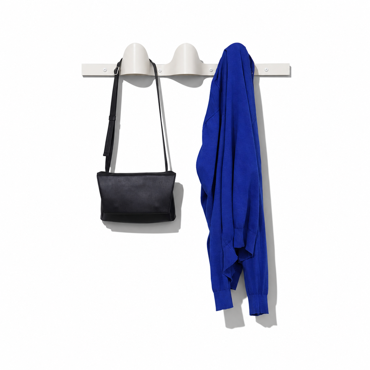Halfwerk Waves coat rack with curved wave design and multiple hooks for hanging coats and accessories.