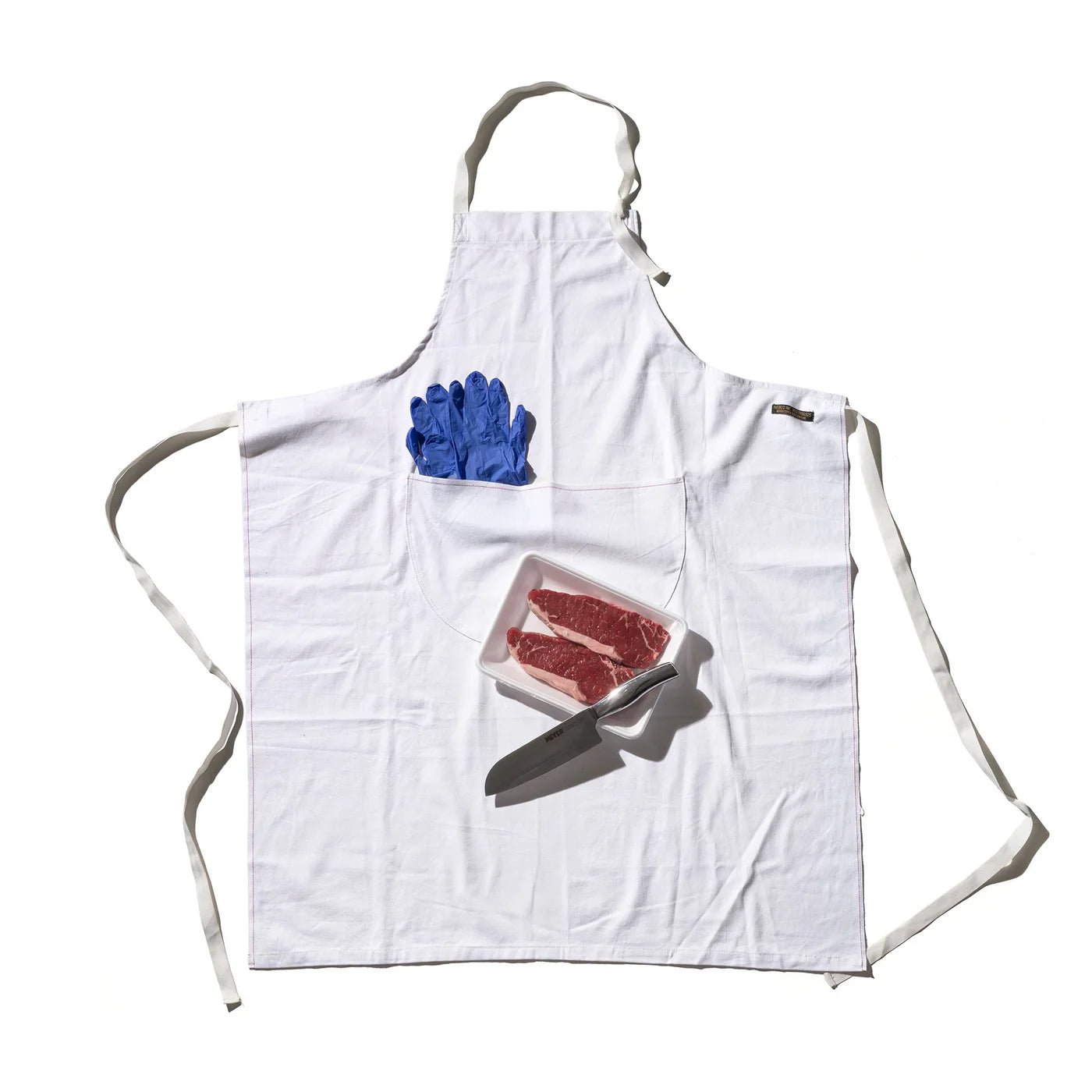 Puebco utility apron with multiple pockets, made of durable fabric, designed for practical use in workshops or kitchens.