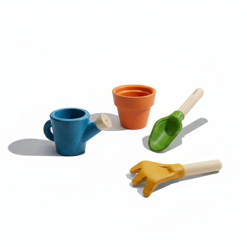 PlanToys gardening set with small shovel, rake, and watering can for kids, perfect for outdoor play and gardening activities.