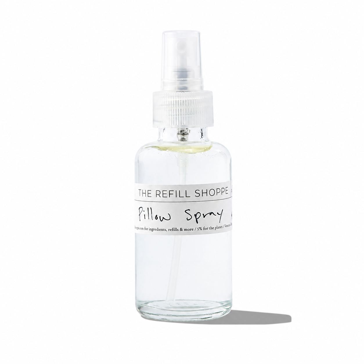 The Refill Shoppe pillow spray bottle with a white label and spray nozzle, designed for relaxing bedroom ambiance.