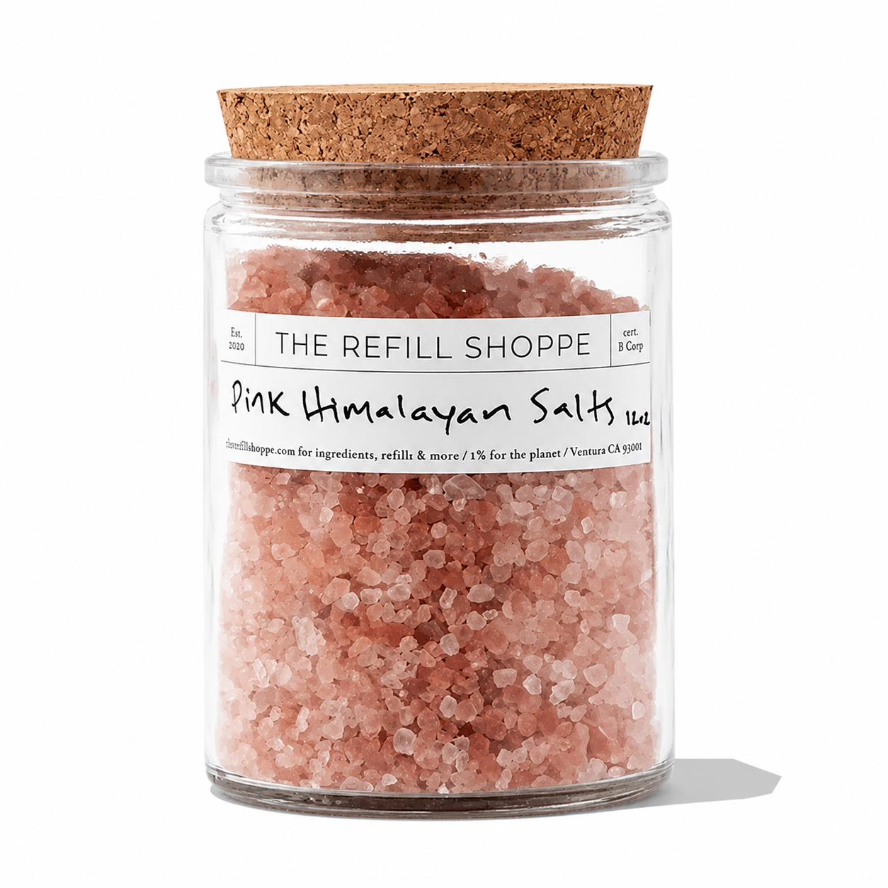 Pink Himalayan bath salts from The Refill Shoppe in a clear glass jar with a wooden scoop, showcasing the pink crystalline salt.