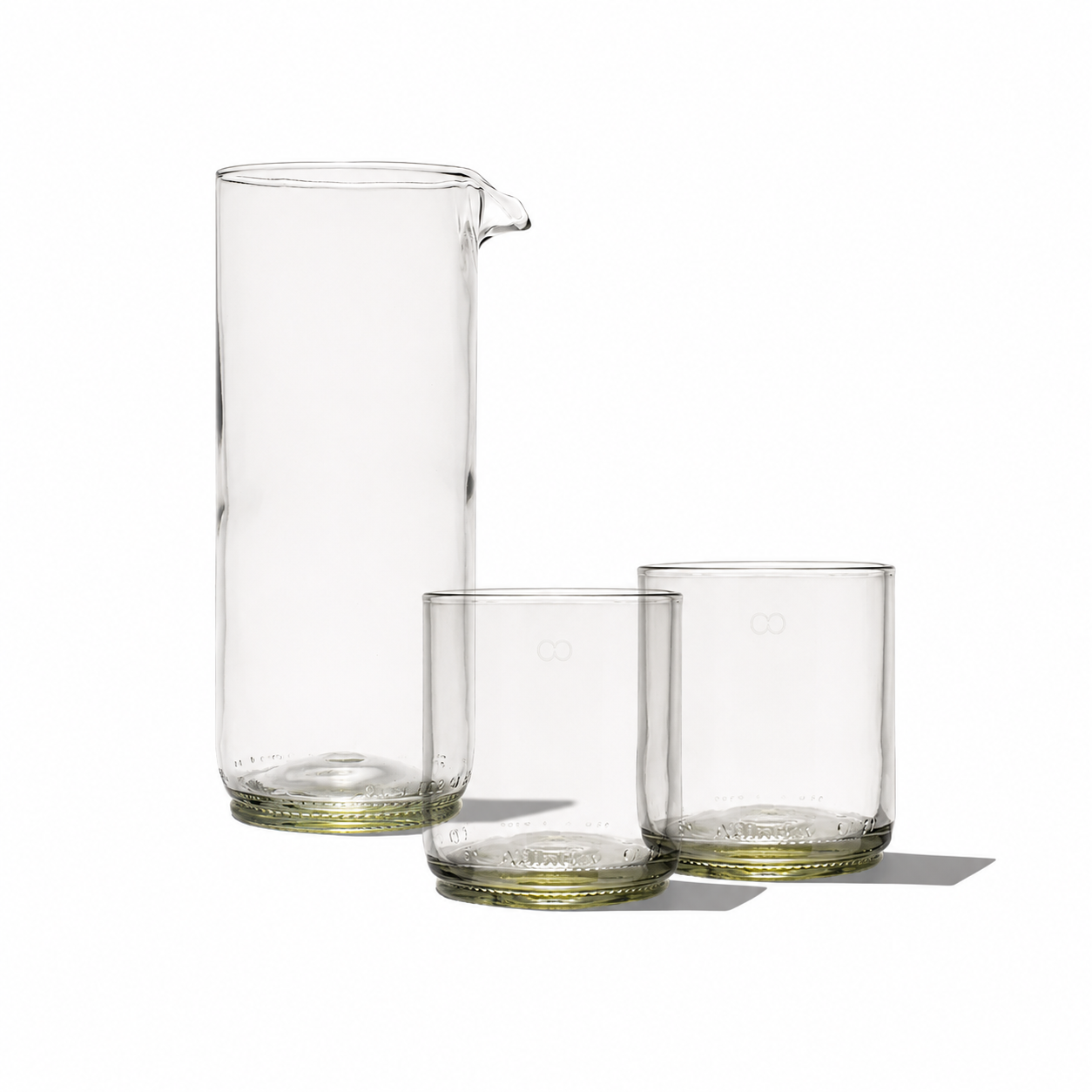 Rebottled glass carafe with two short tumblers for serving drinks, clear and stylish with a sleek design.