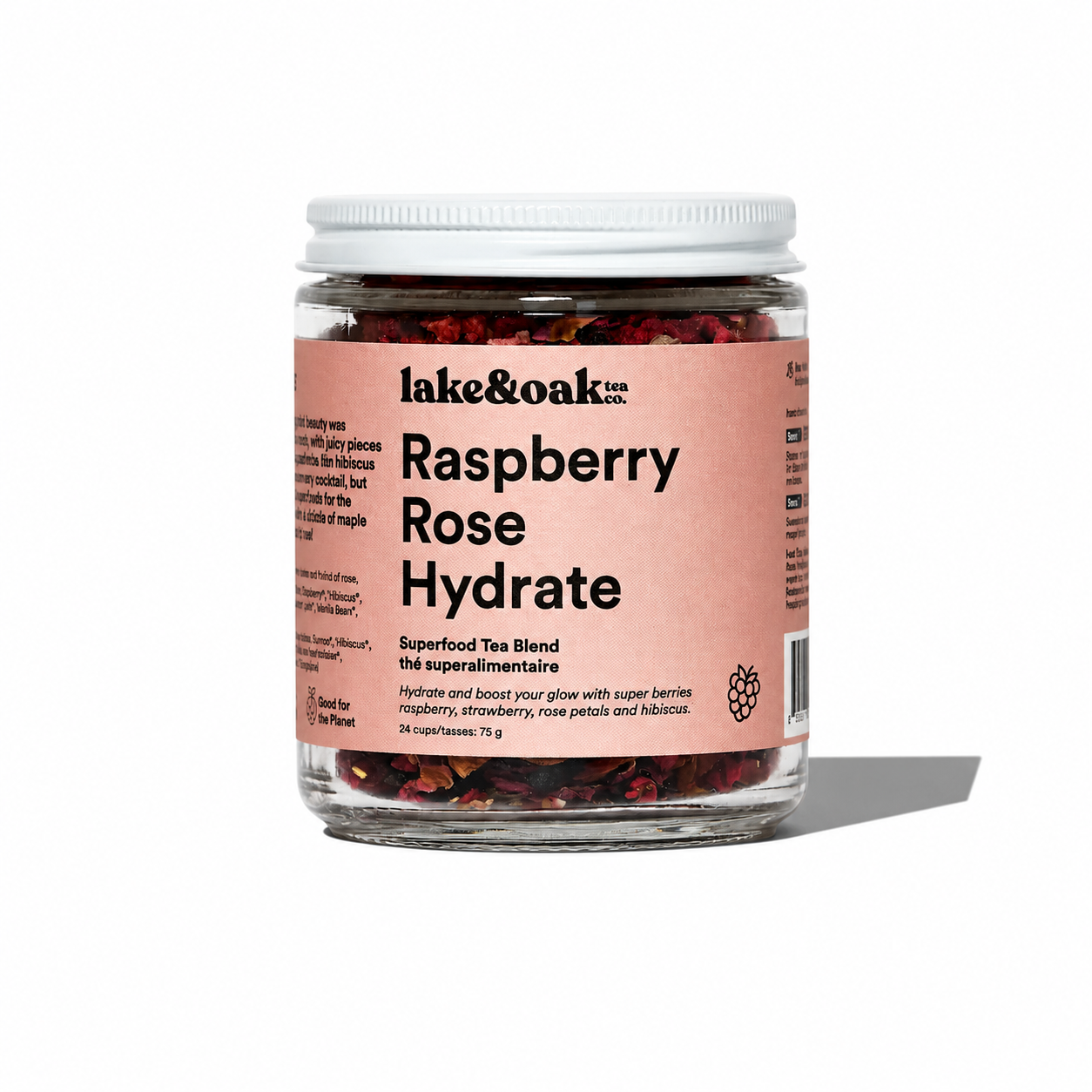 A cup of Raspberry Rose Hydrate tea by Lake & Oak Tea Co. with fresh raspberries and rose petals on a wooden table.