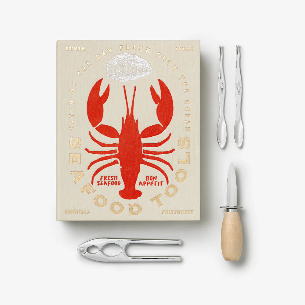 Printworks seafood tools gift set with lobster crackers, seafood forks, and nut picks arranged on a wooden surface.