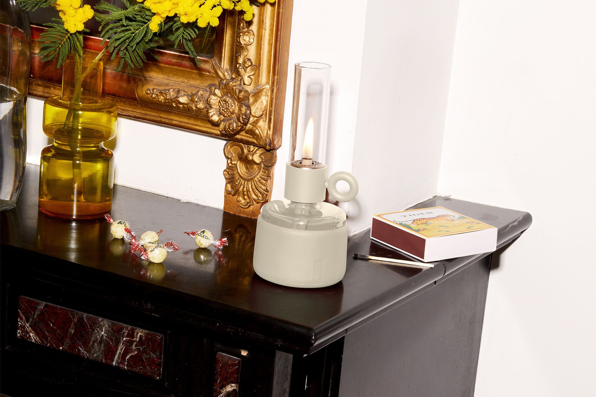 Cream-colored Flamtastique XS Fatboy lighting with warm glow, showcasing its modern, compact design in a cozy ambiance setting.