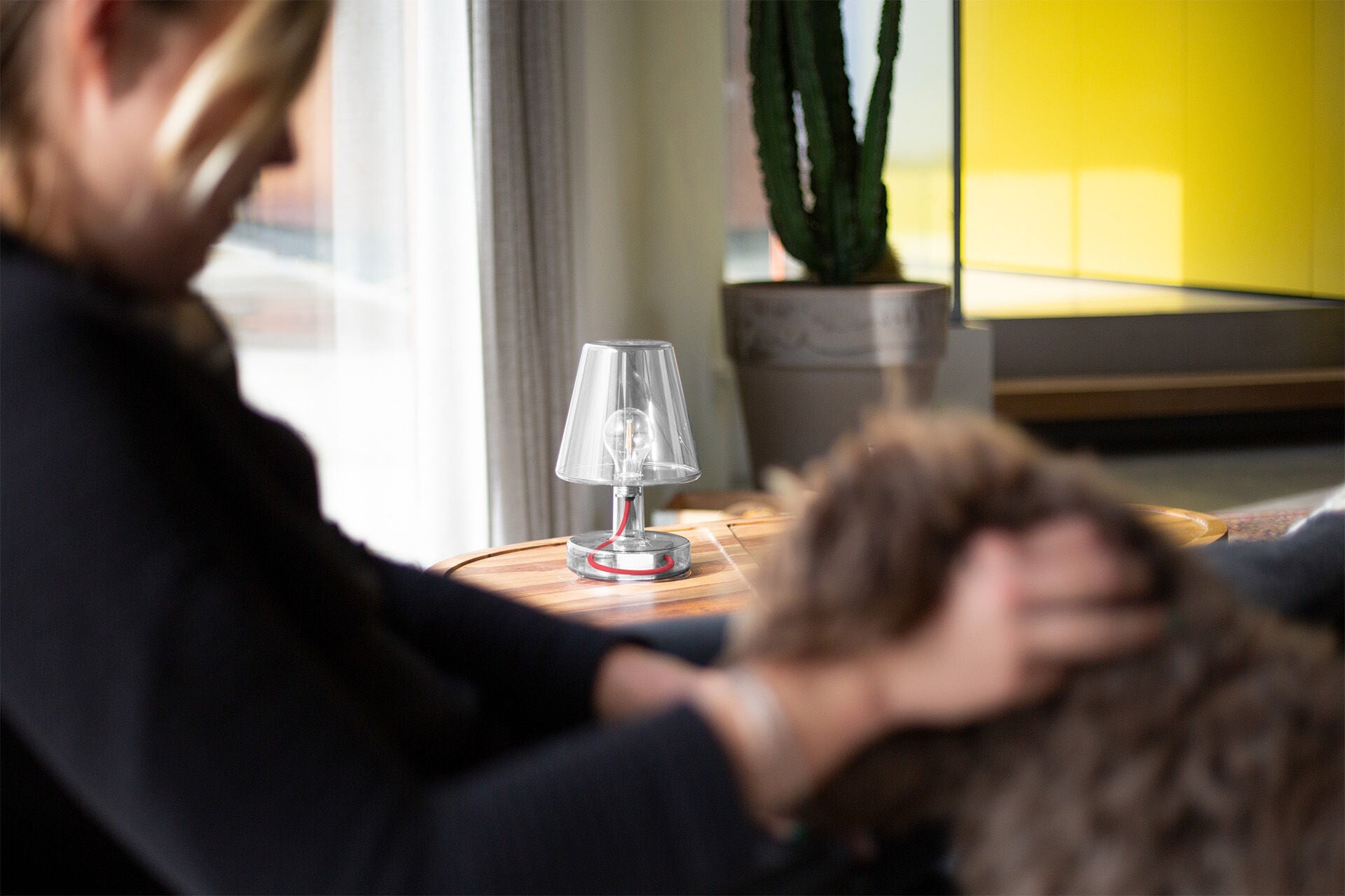 Transloetje Transparent by Fatboy, a stylish glass table lamp with a clear, modern design and warm ambient lighting.