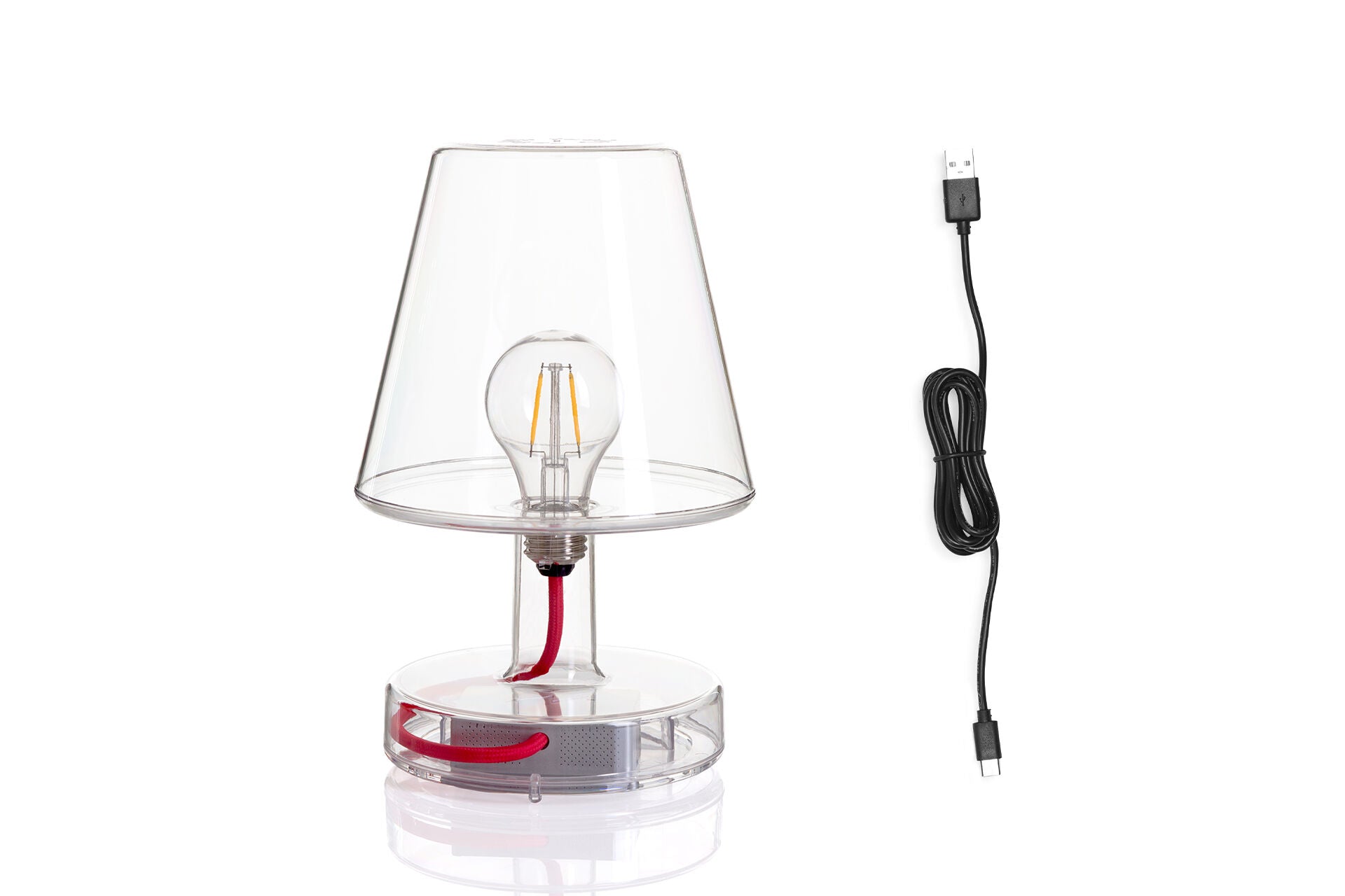 Transloetje Transparent by Fatboy, a modern transparent LED table lamp with a smooth, rounded design on a wooden surface.