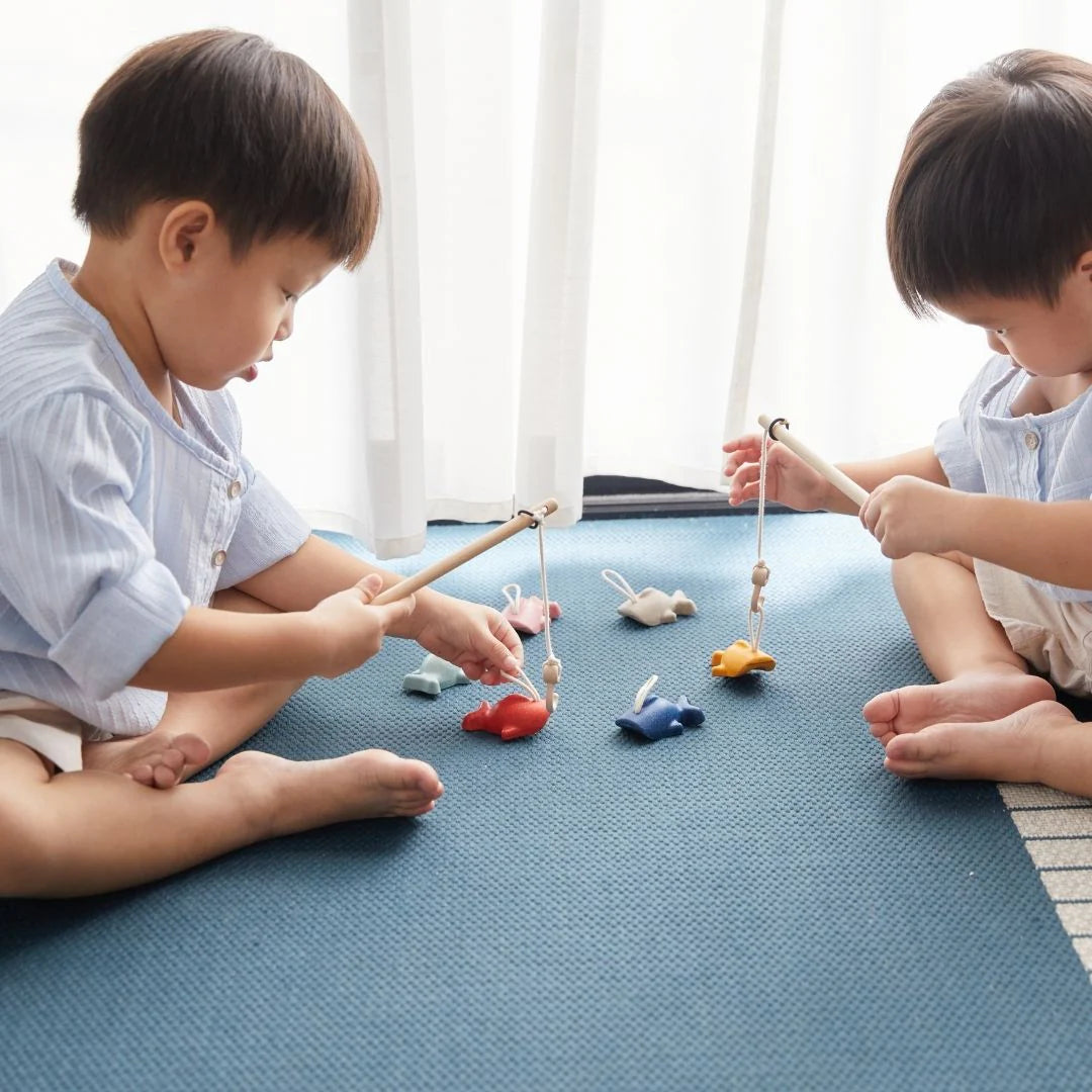 PlanToys fishing game with wooden fishing rods and colorful fish, ideal for children's educational play and fine motor skills development.