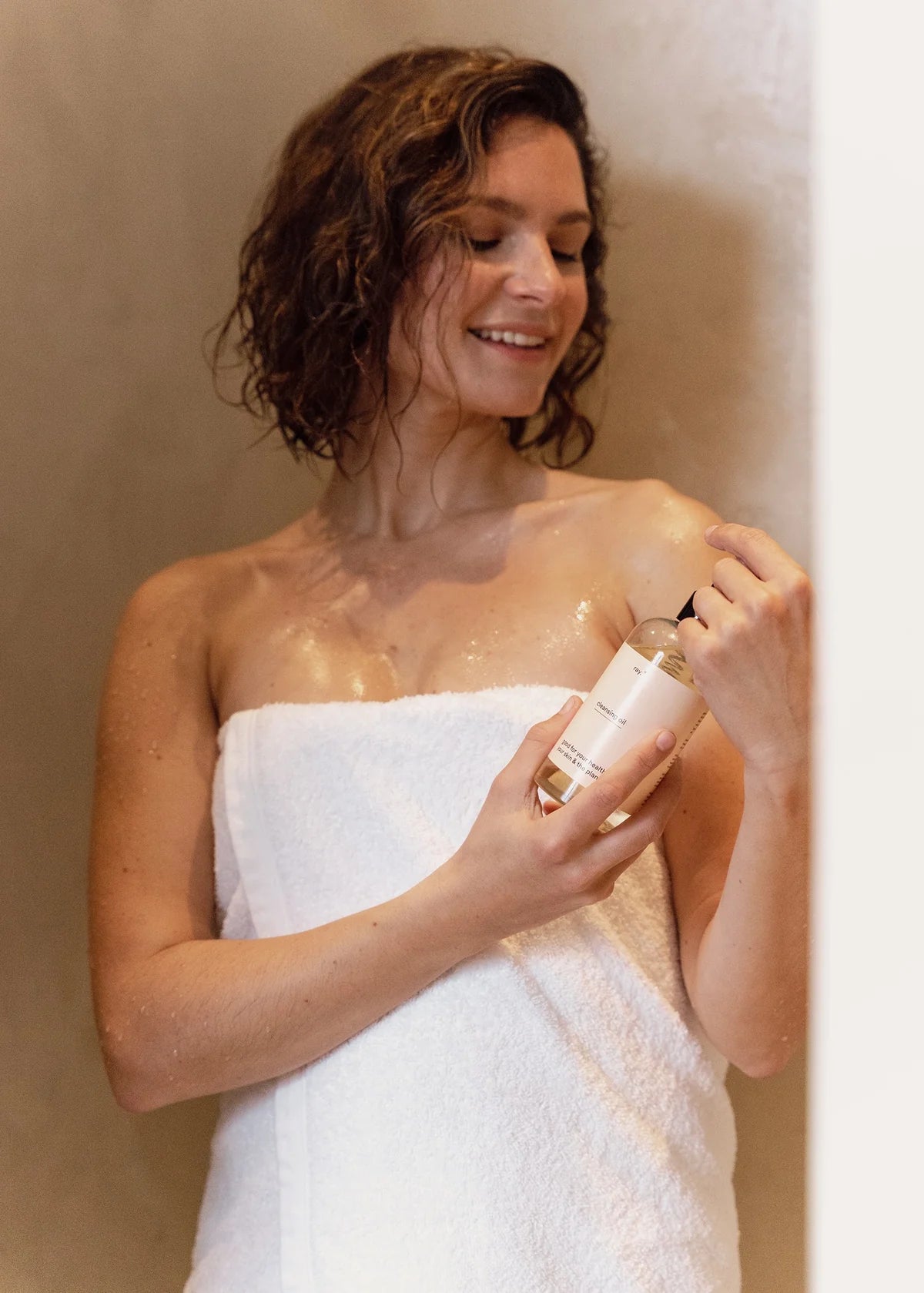 Ray Cleansing Shower Oil bottle with pump dispenser, showcasing a sleek, transparent container filled with nourishing shower oil.